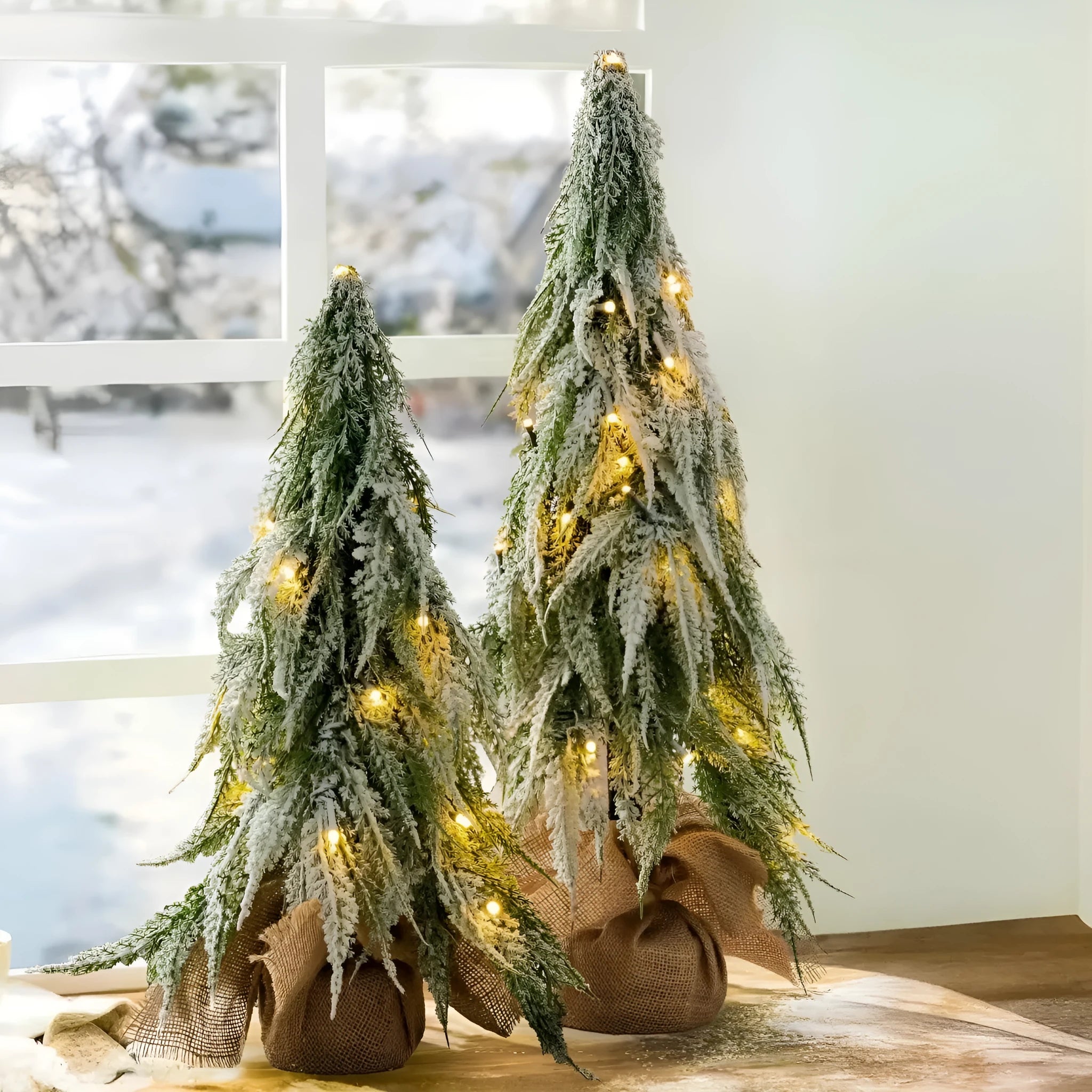 Small 24-inch white artificial Christmas tree with LED lights and snow-covered branches on a desktop.
