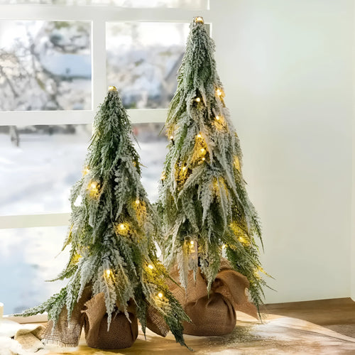 Small 24-inch white artificial Christmas tree with LED lights and snow-covered branches on a desktop.