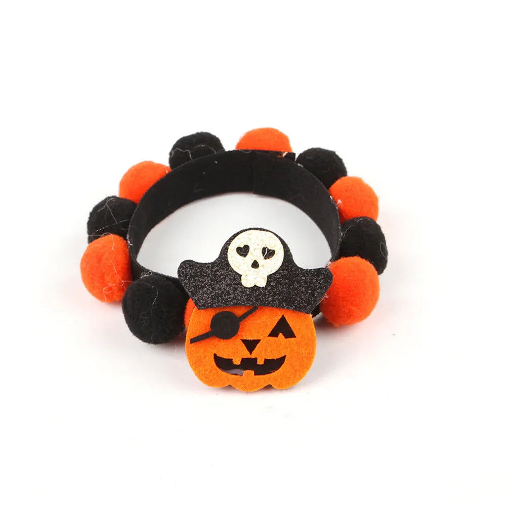 Halloween dog collar with a large orange pom-pom and pumpkin design on an adjustable black band.