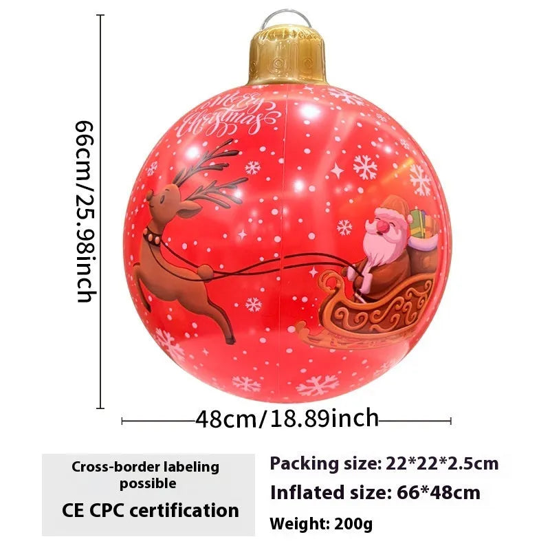 Large red and white inflatable Christmas ball with snowflake design in garden setting