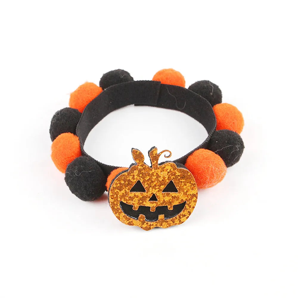 Halloween dog collar with a large orange pom-pom and pumpkin design on an adjustable black band.