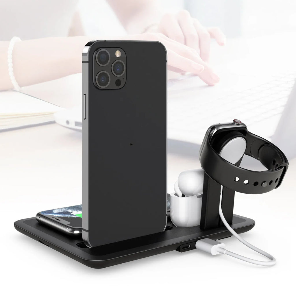 Black and white wireless charging station for phone, smartwatch, and headphones on a desk.