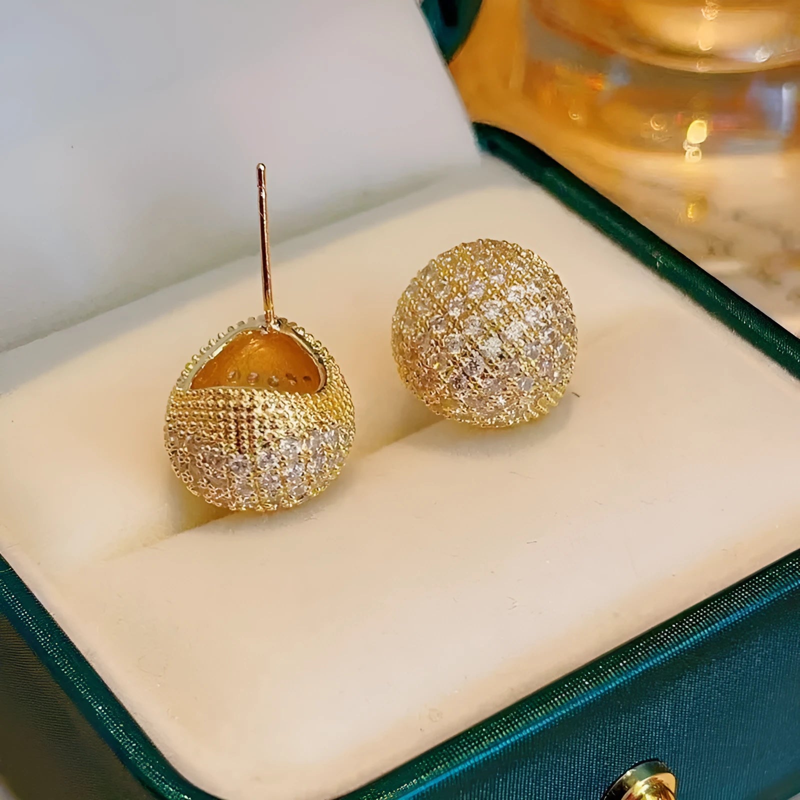 Geometric drop-shaped ear clips with full diamond detailing and sphere elements in gold and white colour options