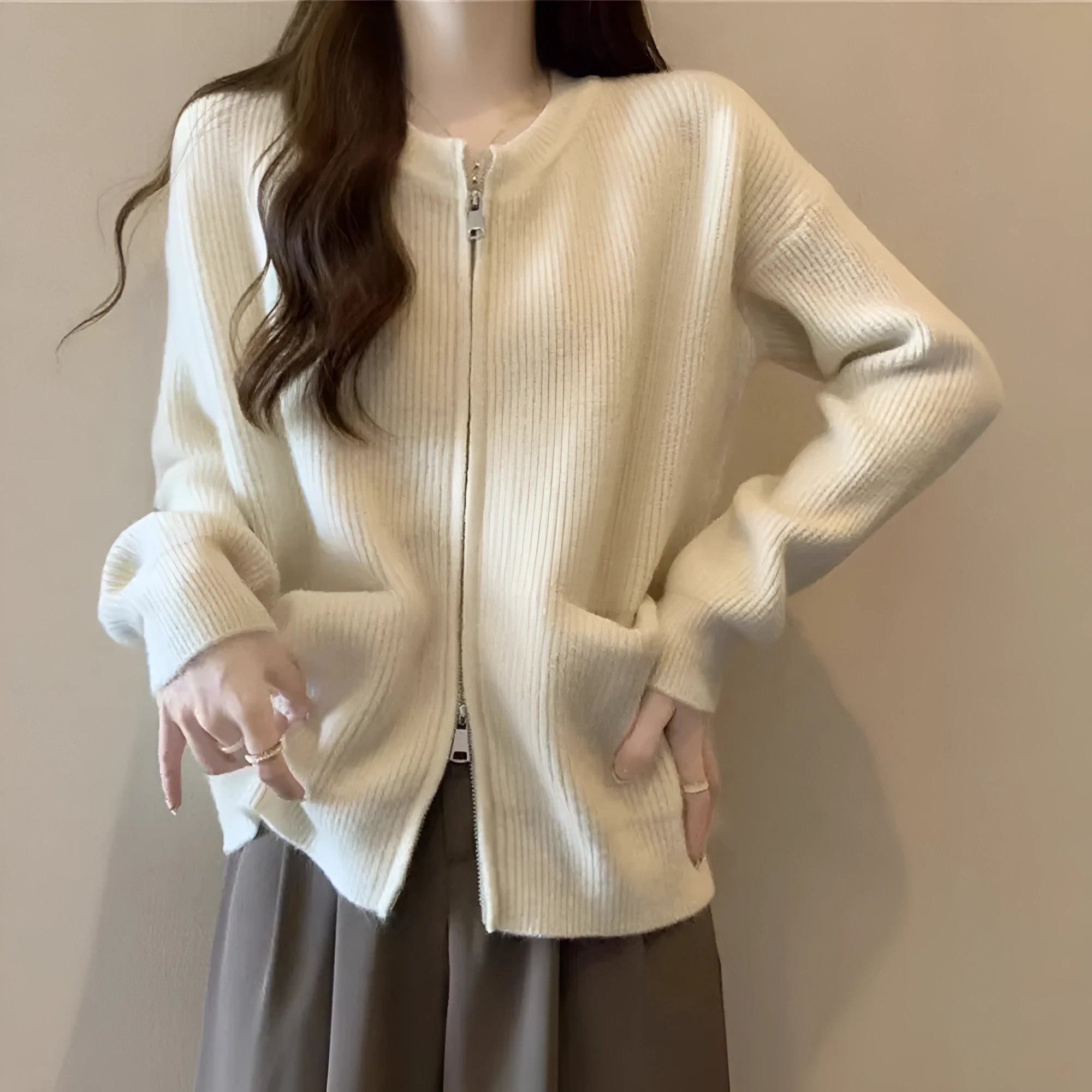 Beige soft viscose knit cardigan with long sleeves shown on a hanger.