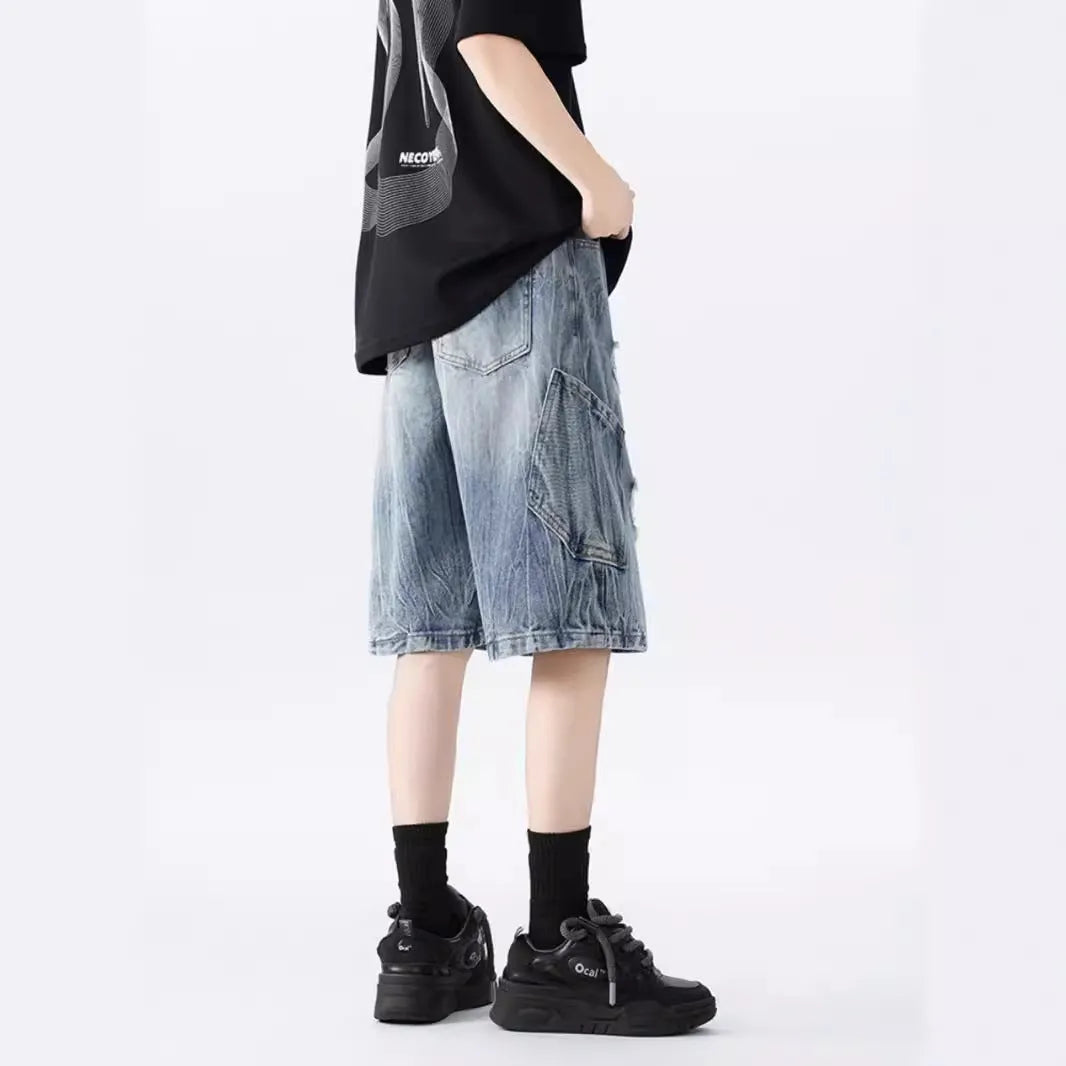 Man's loose-fit ripped denim shorts in washed black showing distressed details and retro styling