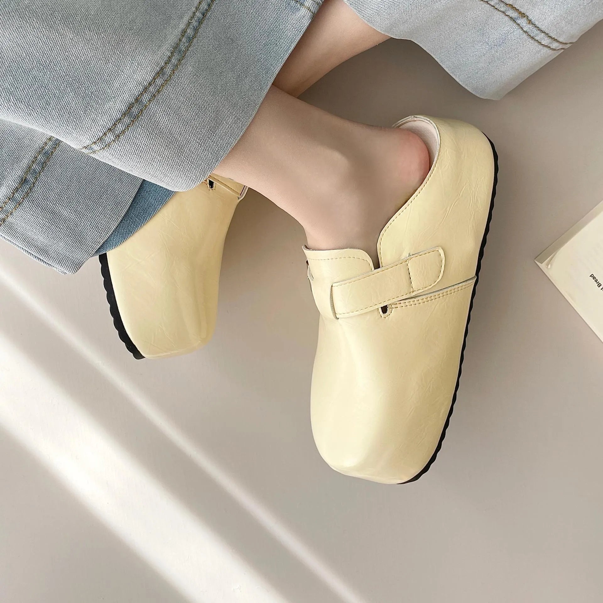 Flat buckle casual sneakers in yellow, black, silver, and creamy-white on a white background.