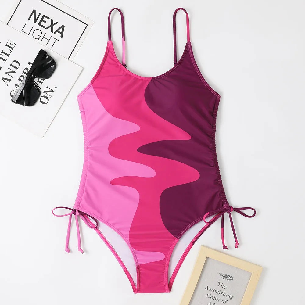 Women's sleeveless backless one-piece swimsuit in a striped pattern, shown in blue.