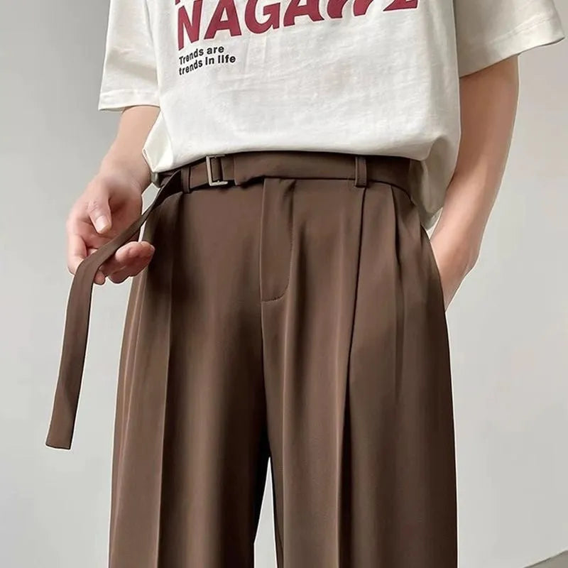 A pair of thin, black wide leg trousers with a straight cut and loose fit, laid flat.