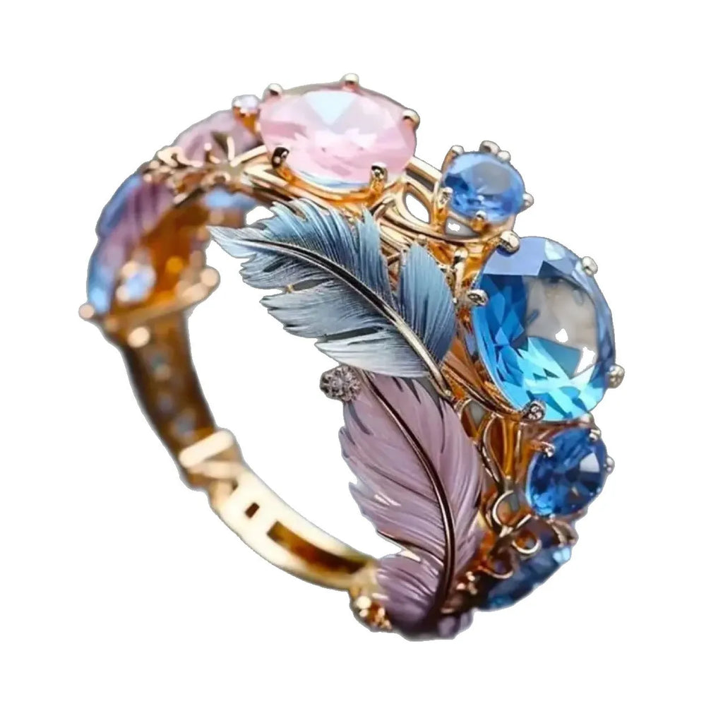 Gold-coloured brass feather ring with geometric embossed design and inlaid zircon stones