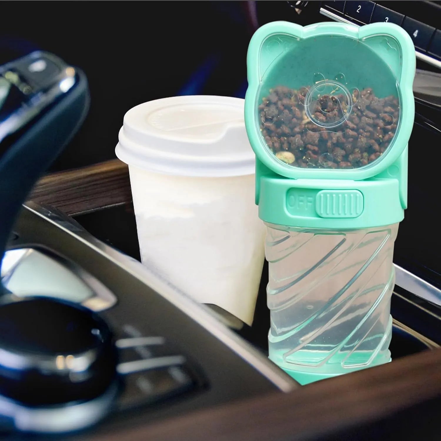 Green 3-in-1 portable pet water bottle with food container and waste bag dispenser, held by its hand strap.