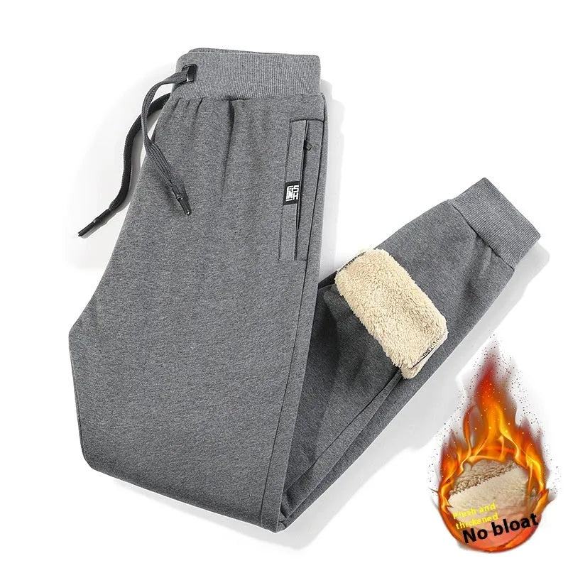 Men's grey oversized fleece-lined cotton track pants with drawstring waist on a hanger.