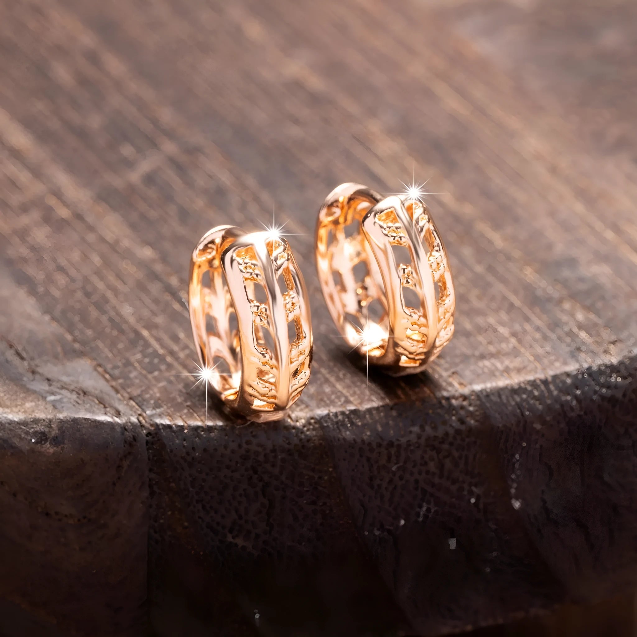 Small copper earrings with a hollowed-out heart-shaped leaf design in rose gold finish.