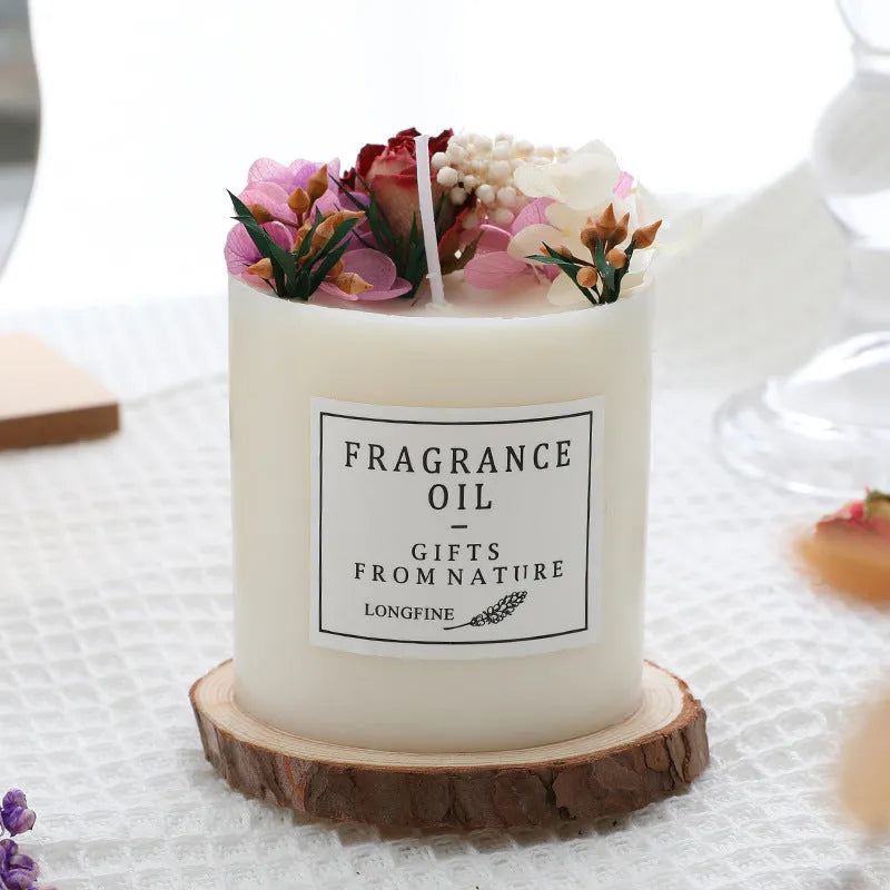 Decorative aromatherapy candle with dried flowers embedded in solid wax, shown with optional wooden chip base.