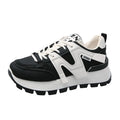 A pair of low-top black or white sneakers with a round toe, lace-up front, and flat rubber sole.