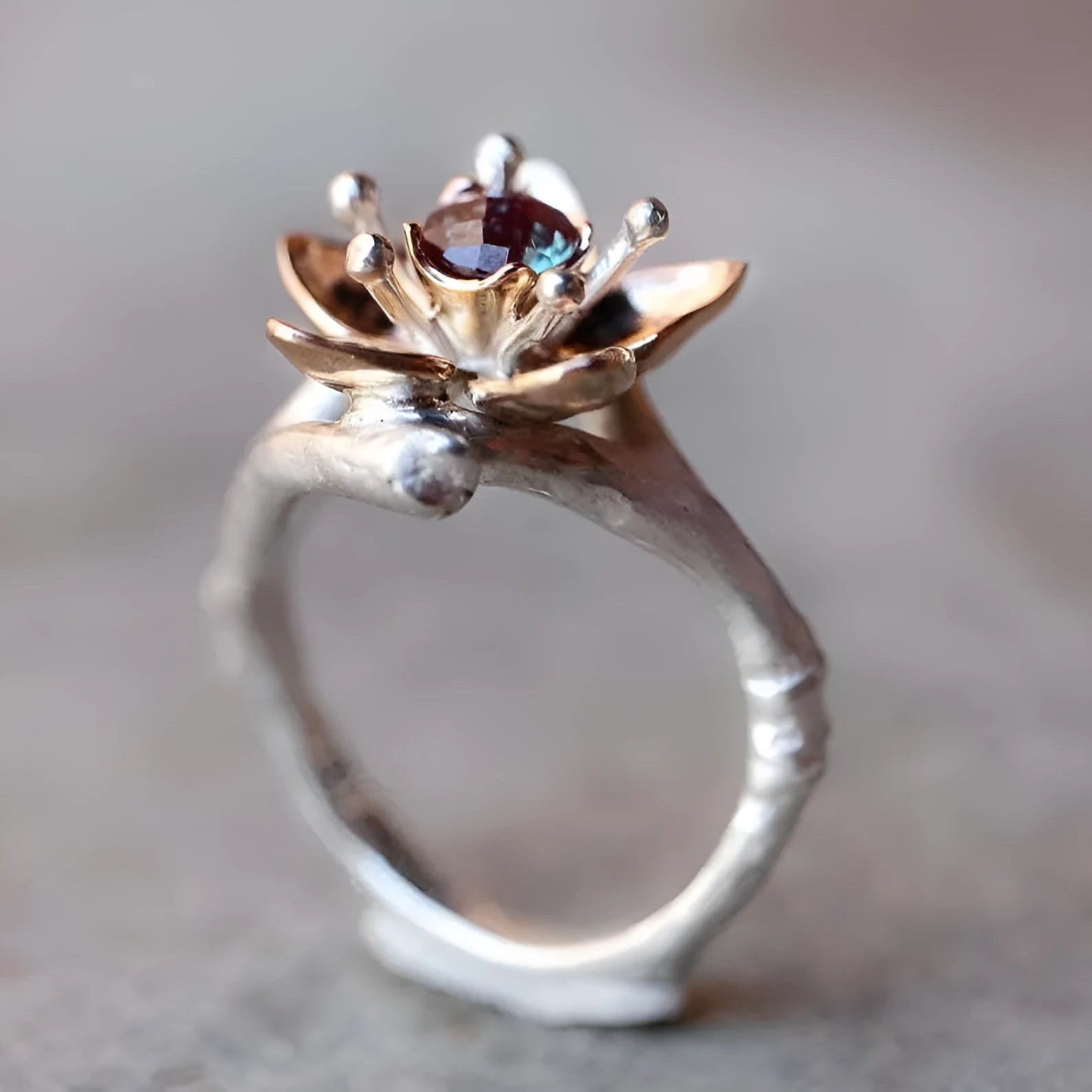 Silver and rose gold two-tone floral design alloy ring on a geometric band.