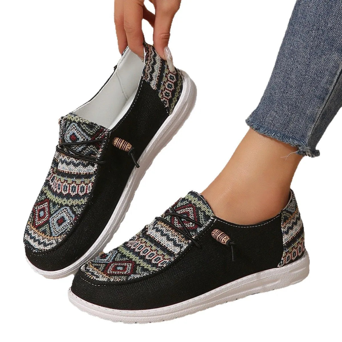 Women's black slip-on flat shoes with round toe and rubber sole on a plain background