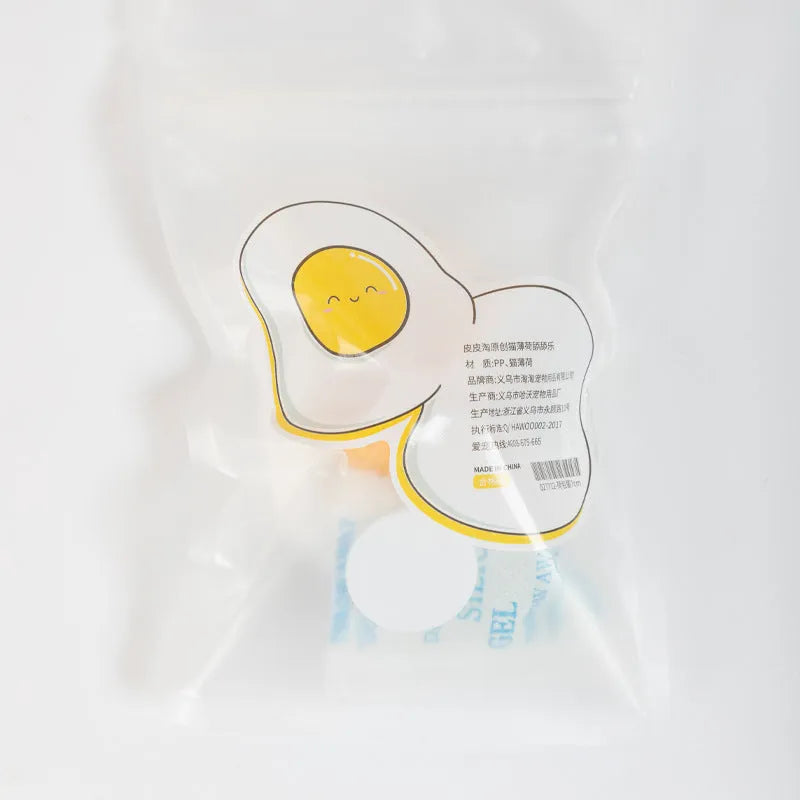 Soft plush catnip ball toy with suction cup mounted on a wall, shown in fried egg and poached egg shapes.