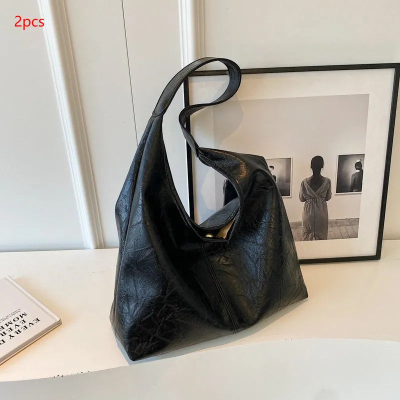 Soft leather shoulder bag in black with sandwich pocket design and shoulder strap