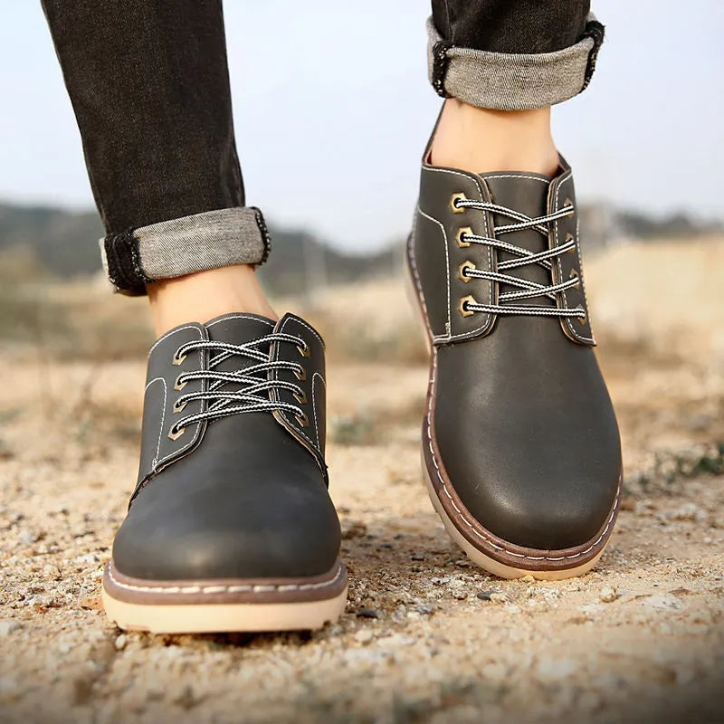 Men's black British style mid-top leather ankle boots with rubber sole.