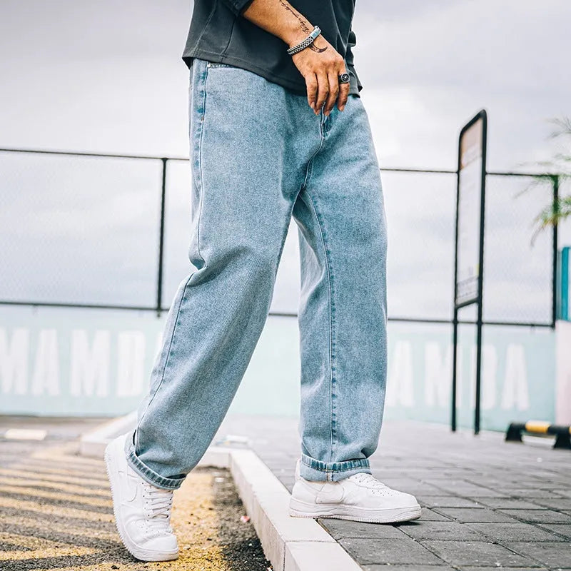 Men's loose straight-leg jeans in cotton denim, shown in dark blue, with a zipper fly and mid-rise waist.