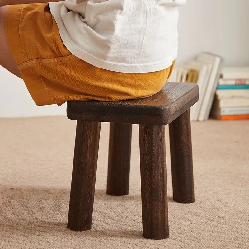 Solid wood shoes changing stool with distressed finish and bracket leg structure.