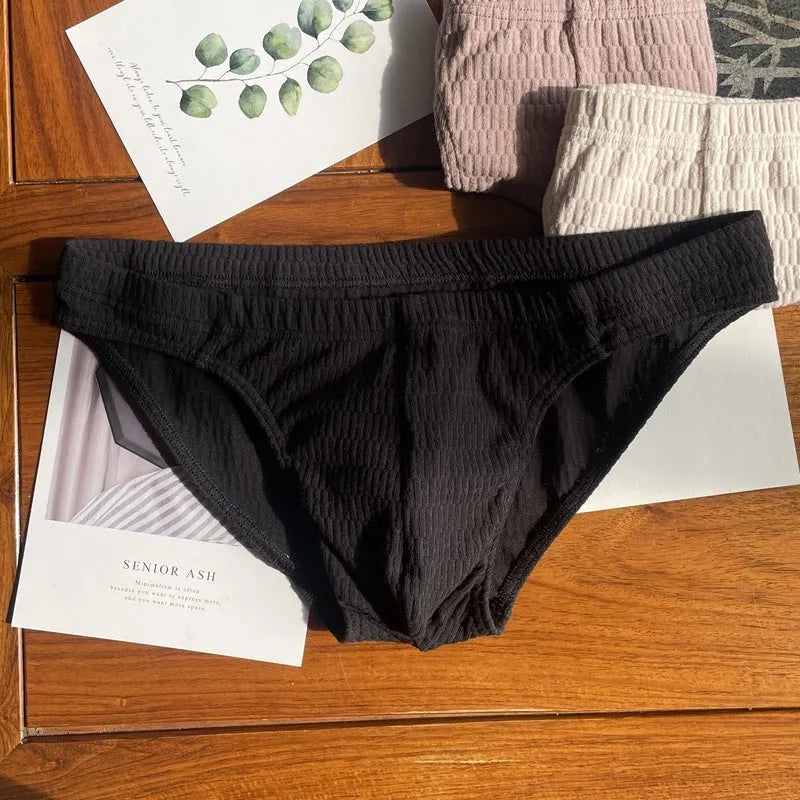 Men's solid colour cotton briefs with mid waist and triangle style in apricot black and skin colour.