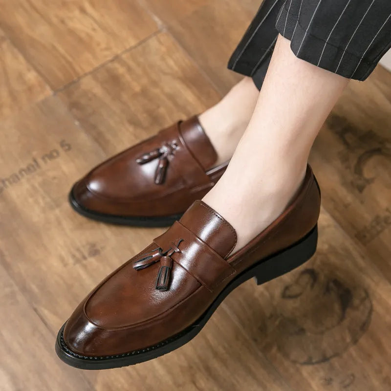 Men's black slip-on business casual shoes with a tassel detail on the artificial PU upper