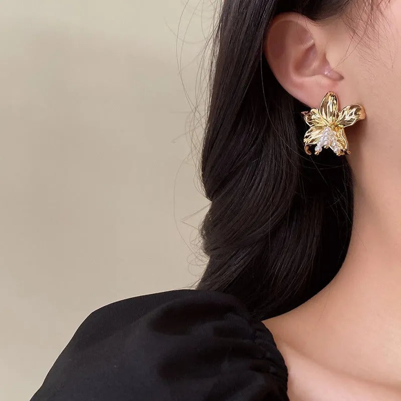 Gold H1795 metal flower earrings with pearls and an exaggerated, personalised design.