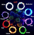 Silver wire LED string lights coiled around wine bottle with illuminated bulbs and bottle stopper fitting