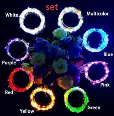 Silver wire LED string lights coiled around wine bottle with illuminated bulbs and bottle stopper fitting