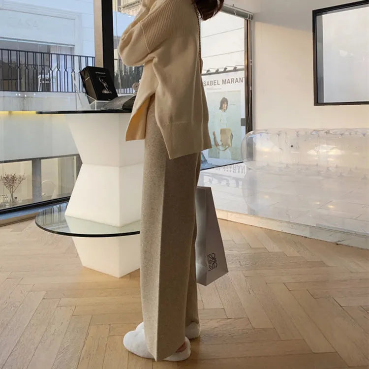 Women's high waist wide-leg knit trousers in cream white colour, laid flat to show straight-leg cut.