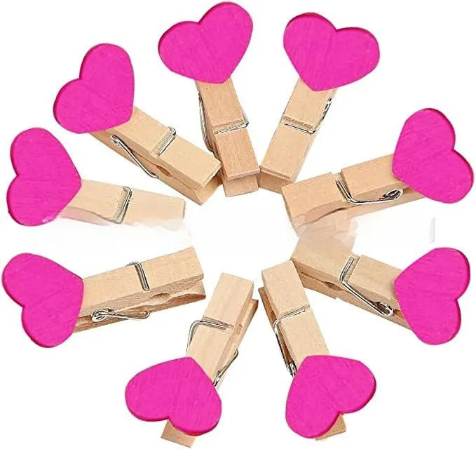 Five handmade wooden heart-shaped clips in red, white, and rose red on a plain background.