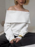 Grey off-the-shoulder sweater with a 3D textured pattern and strapless design.
