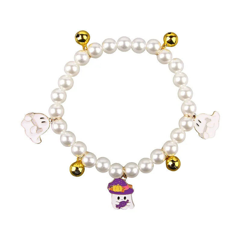 Purple simulated pearl cat collar with three Halloween pumpkin charms: ghost, skull, and smiley face.