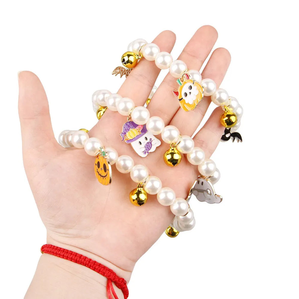 Purple simulated pearl cat collar with three Halloween pumpkin charms: ghost, skull, and smiley face.