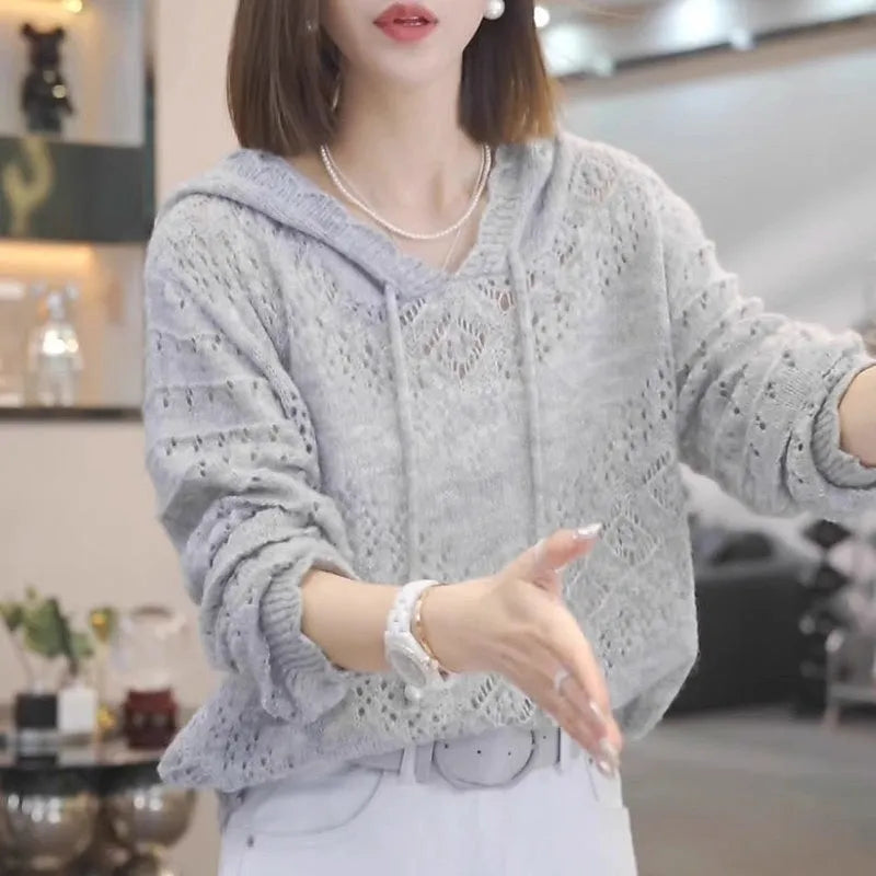 Women's light blue crochet knit hooded longsuit undershirt with long sleeves on a hanger.