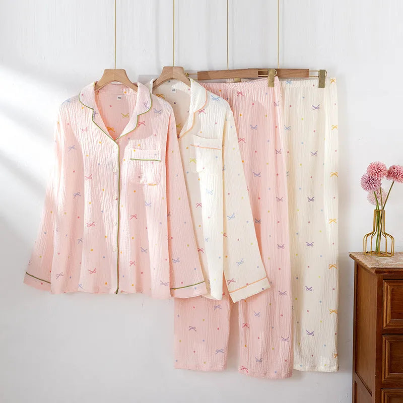 Women's beige long sleeve cotton pajama top and trousers set laid flat.