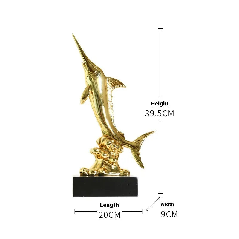 Close-up of a detailed resin European swordfish ornament in bright gold colour on a shelf.