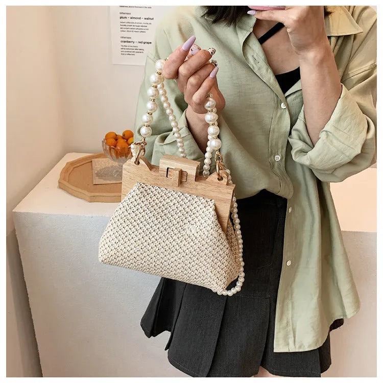 Women's straw shoulder bag with pearl chain strap in beige colour showing organised interior with compartments
