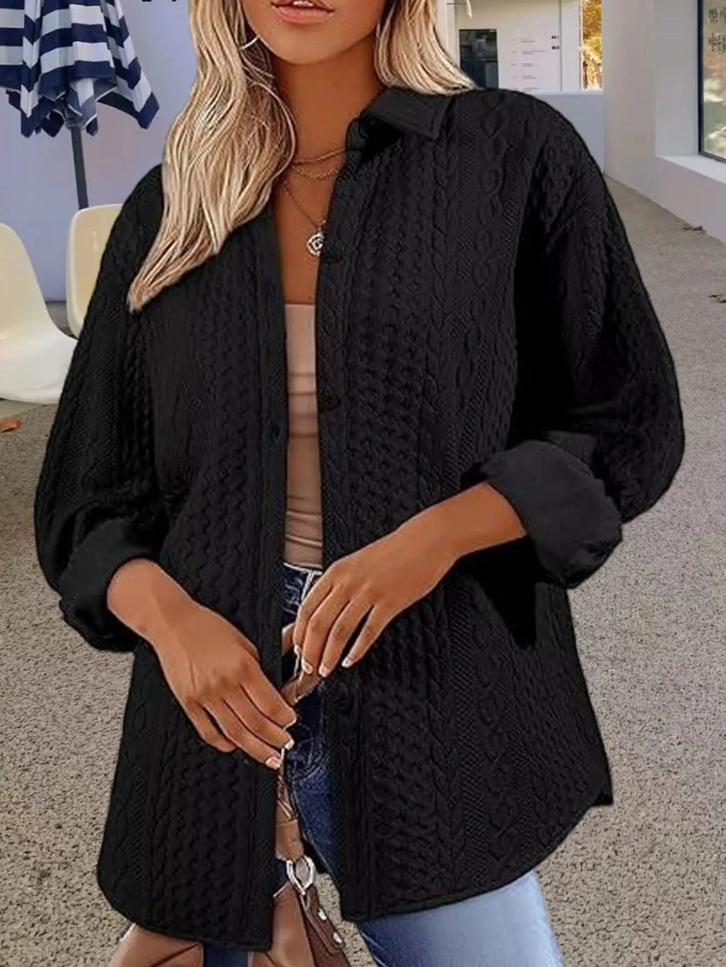 Women's solid colour long sleeve knitted cardigan sweater on a hanger.