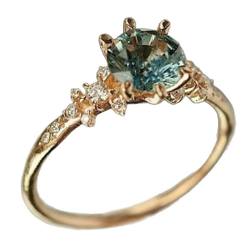 Gold coloured geometric ring with claw setting and square patterned band.