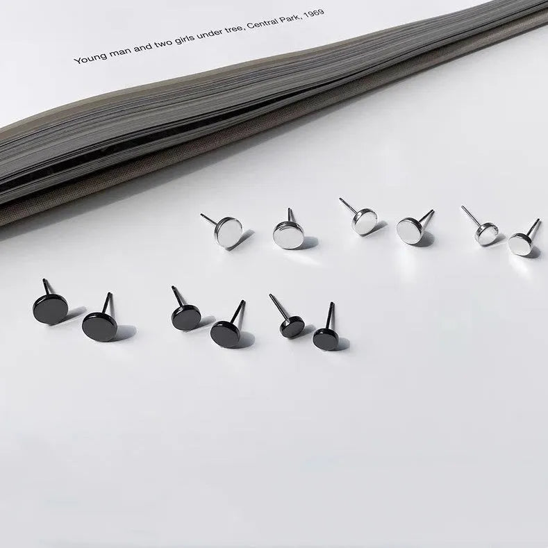 A pair of simple, round, flat-fronted S999 sterling silver ear bone studs on a plain background.