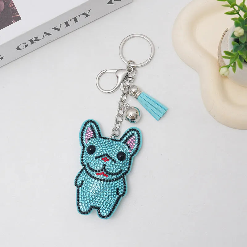 Close-up of a rhinestone dog charm keychain in a caramel colour with sparkling stones on a metal base.