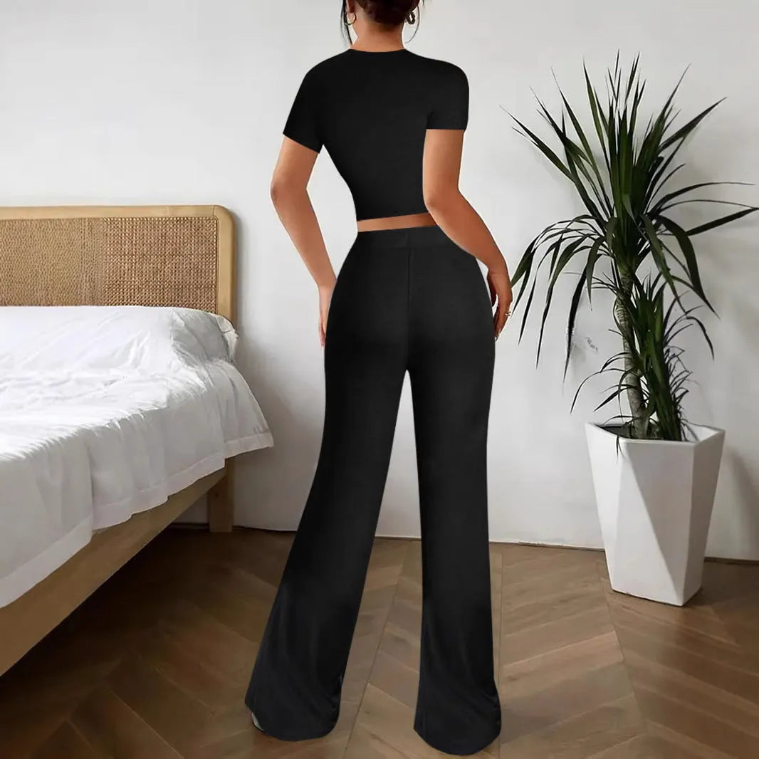 Black women's co-ord set with high waist trousers and regular sleeve T-shirt laid flat