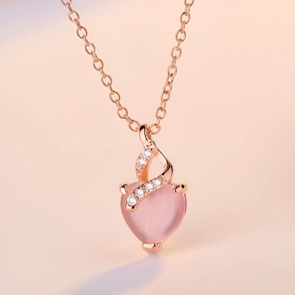 Rose gold heart-shaped pendant necklace with a pink synthetic crystal centre on a matching cross chain.