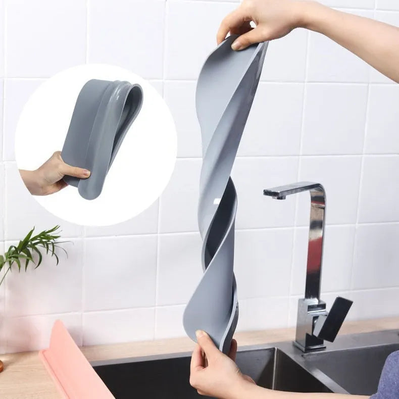 Thick grey silicone kitchen sink water blocking plate sitting on a counter next to a sink