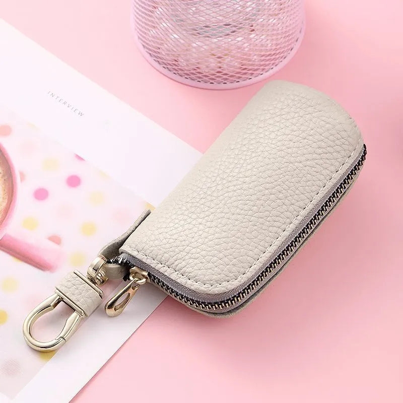 Simple black PU zipper key ring case for car and home keys on a grey background.